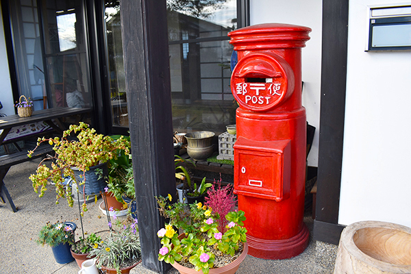 A nostalgic red mailbox sits outside the entrance